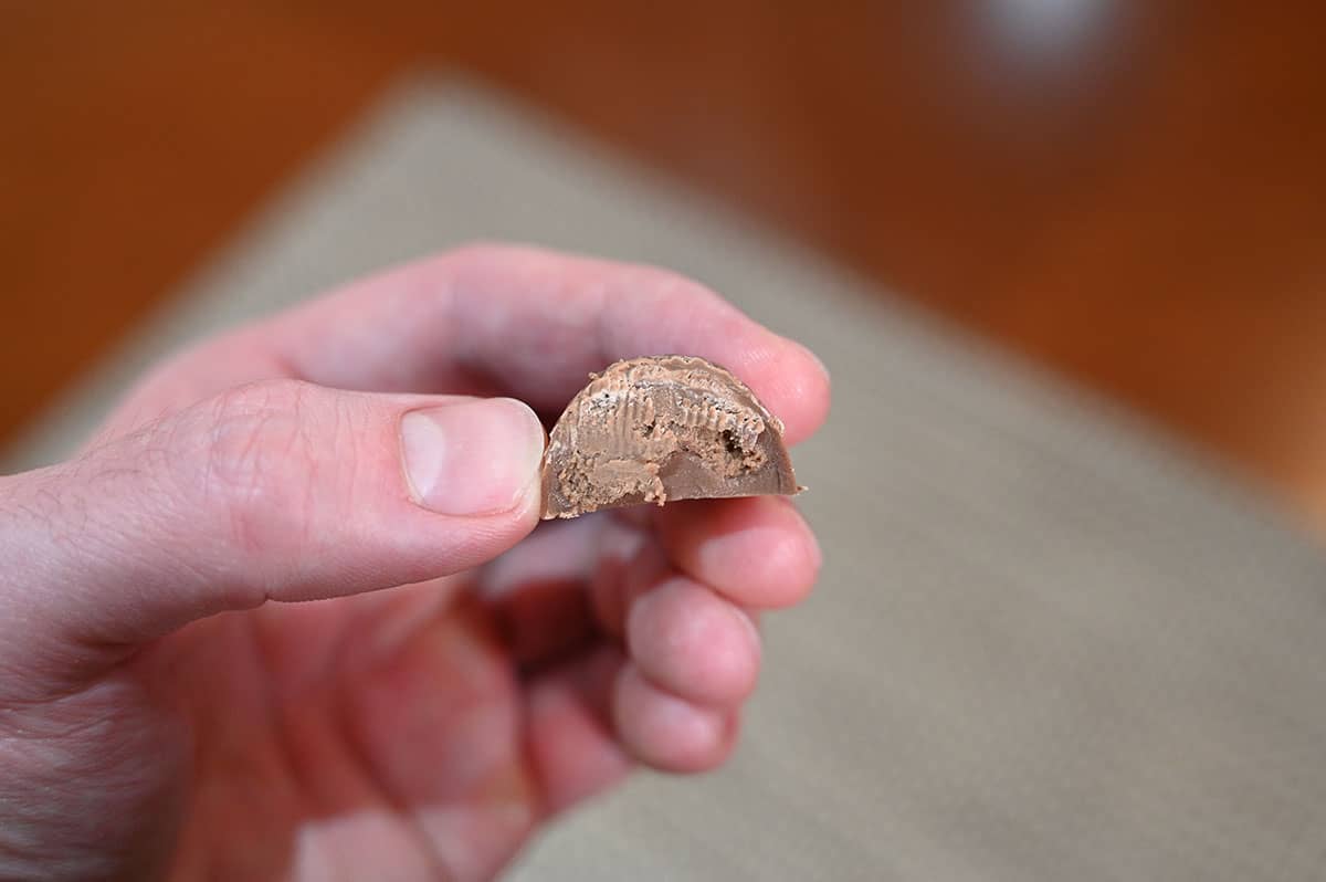 Closeup image of one hedgehog chocolate being held with a bite taken out of it so you can see the inside.