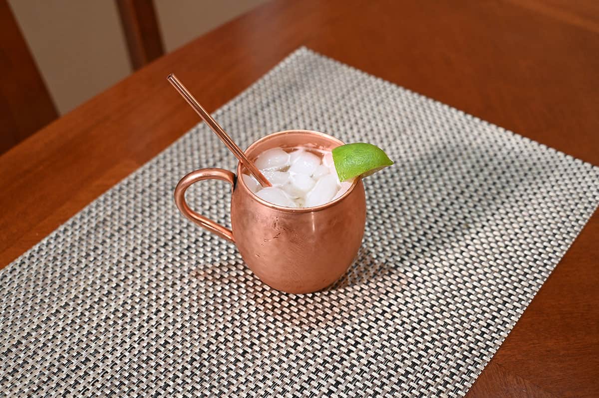 Image of pineapple mule drink beverage in a moscow mule glass, sitting on a table.