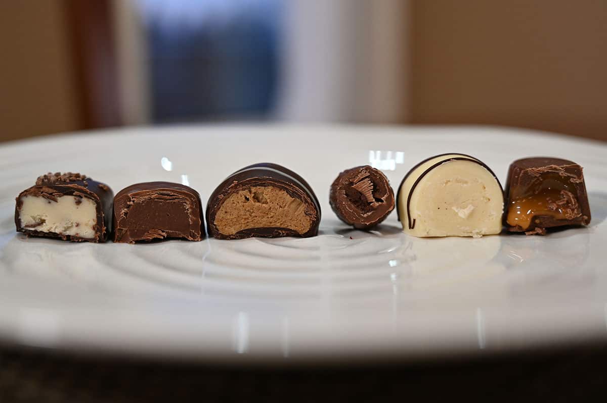 Closeup image of six chocolates cut in half and served on a white plate so you can see the center of each chocolate.