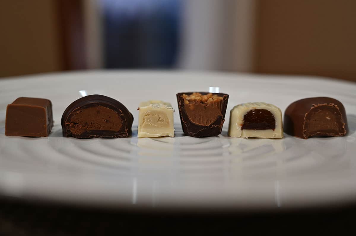 Closeup image of six chocolates cut in half and served on a white plate so you can see the center of each chocolate.