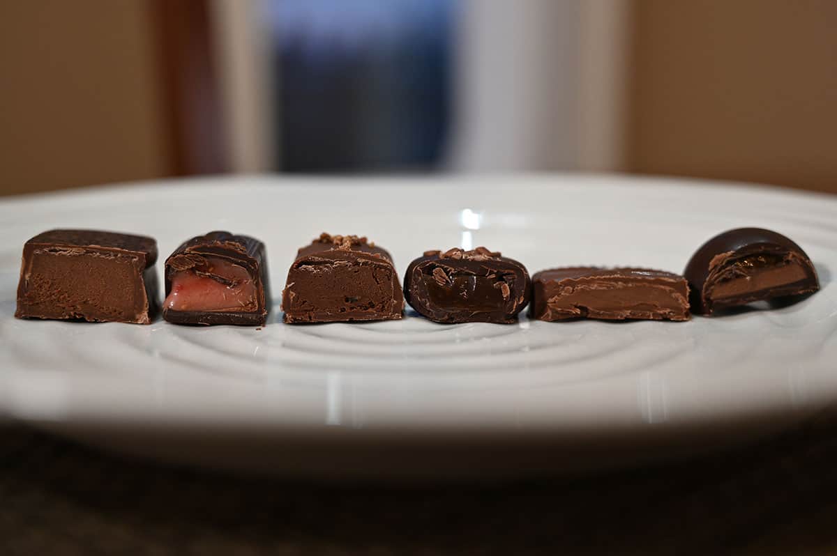 Closeup image of six chocolates cut in half and served on a white plate so you can see the center of each chocolate.