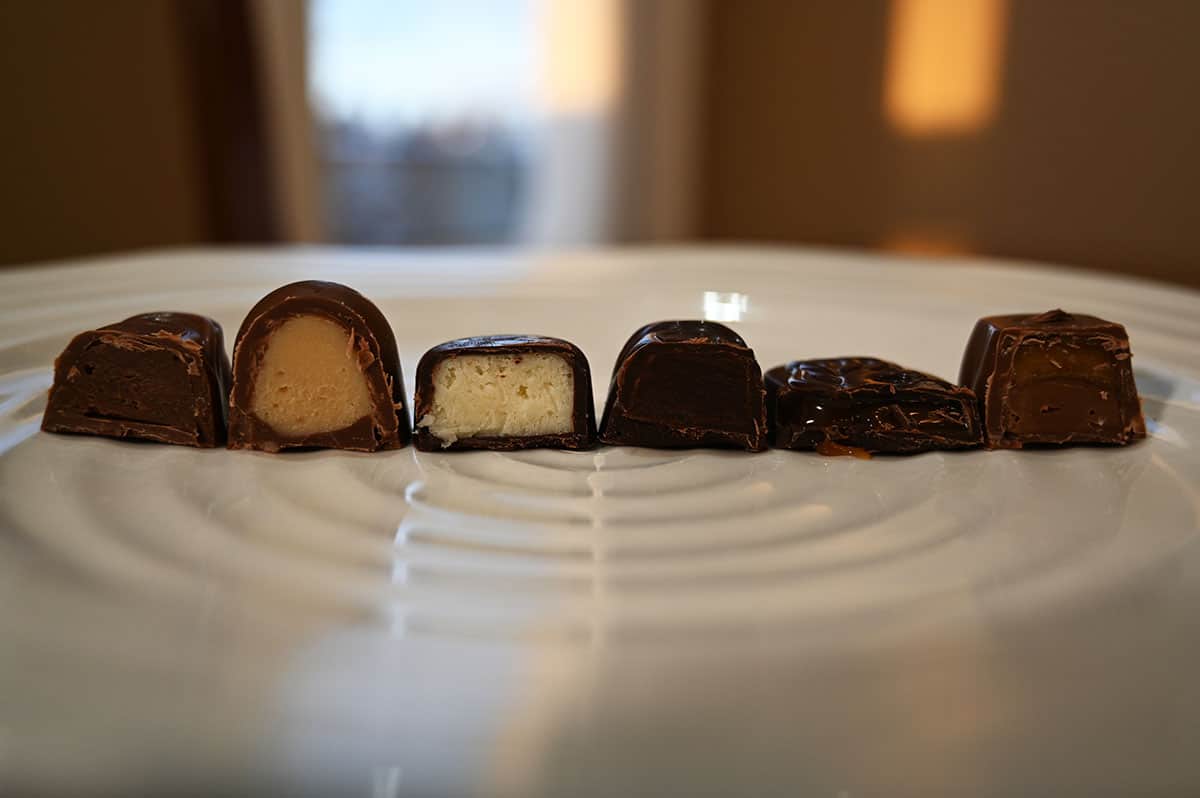 Image of the first six kinds of chocolates served on a white plate and cut in half so you can see the center of each chocolate.
