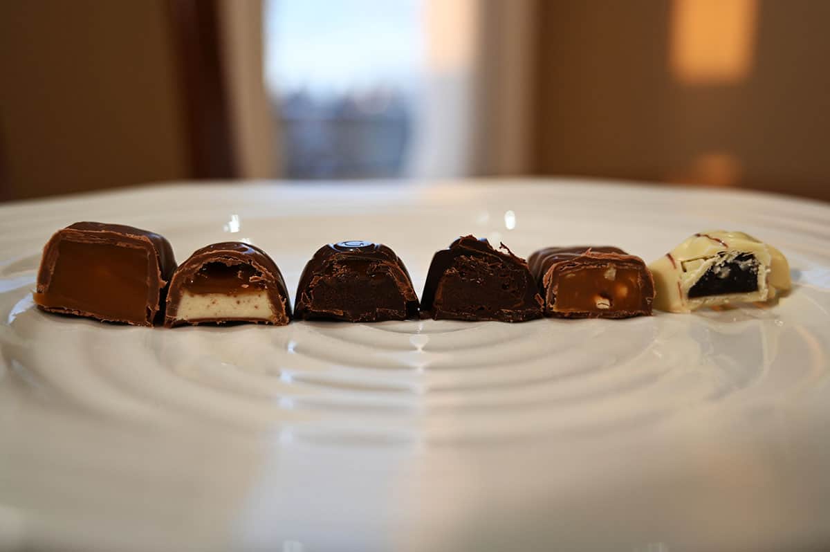 Image of the second six kinds of chocolates served on a white plate and cut in half so you can see the center of each chocolate.