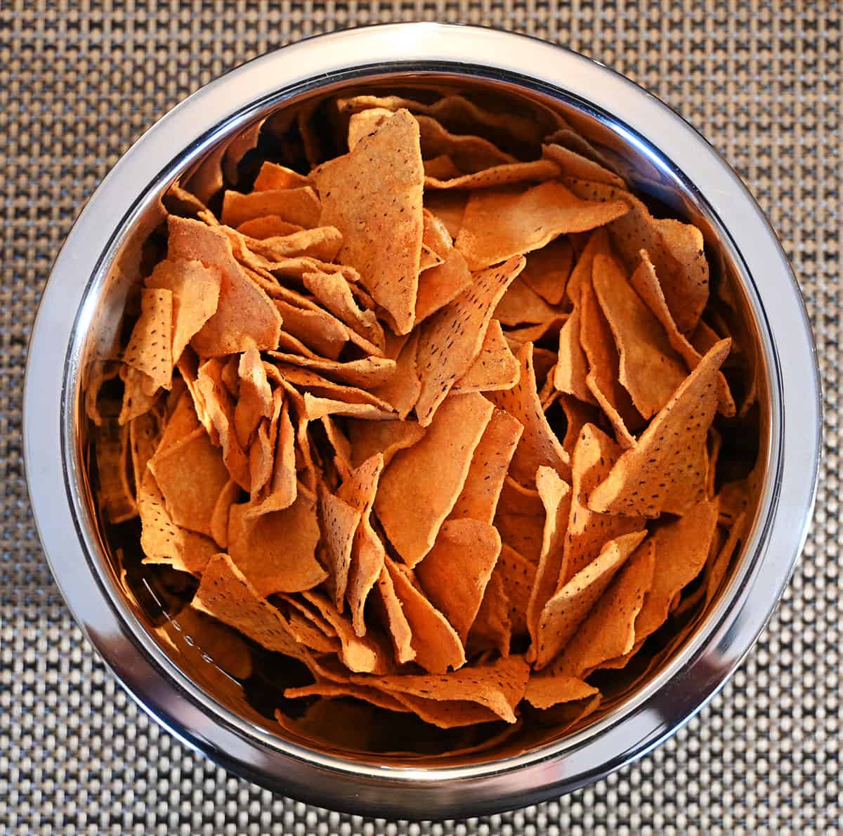 Top down image of a bowl full of chips sitting on a table.