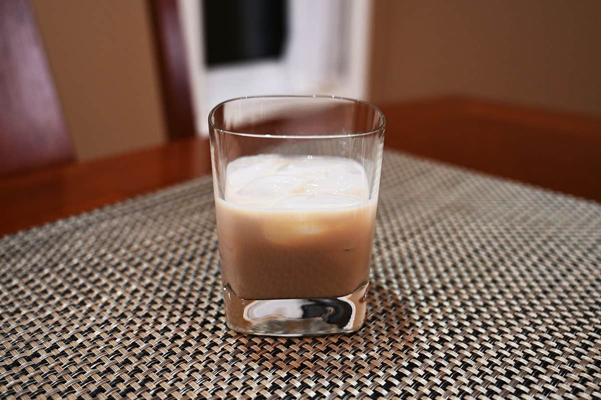 Image of the Irish cream served in a glass with ice sitting on a table.