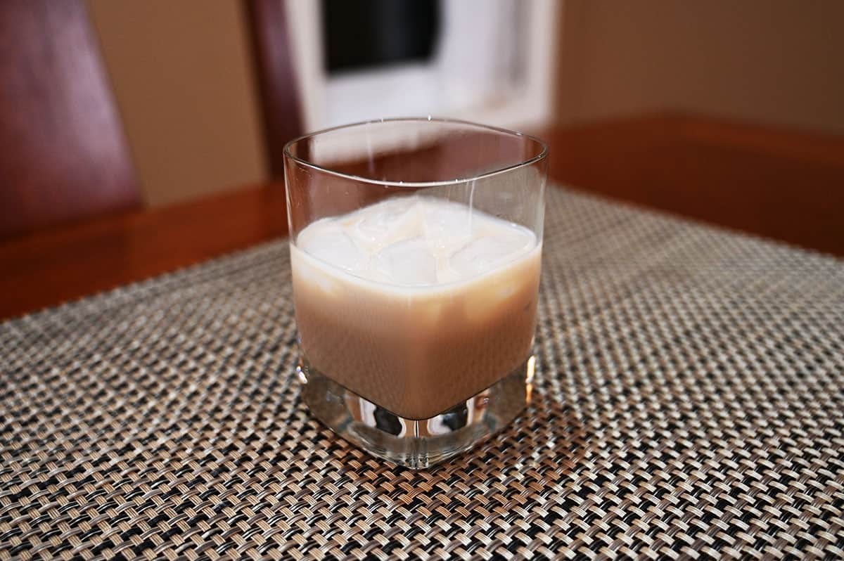 Image of the Irish cream served in a glass with ice sitting on a table.