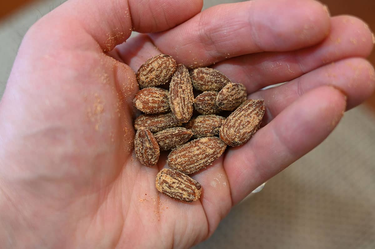 Closeup image of the palm of a hand holding a handful of the almonds. 