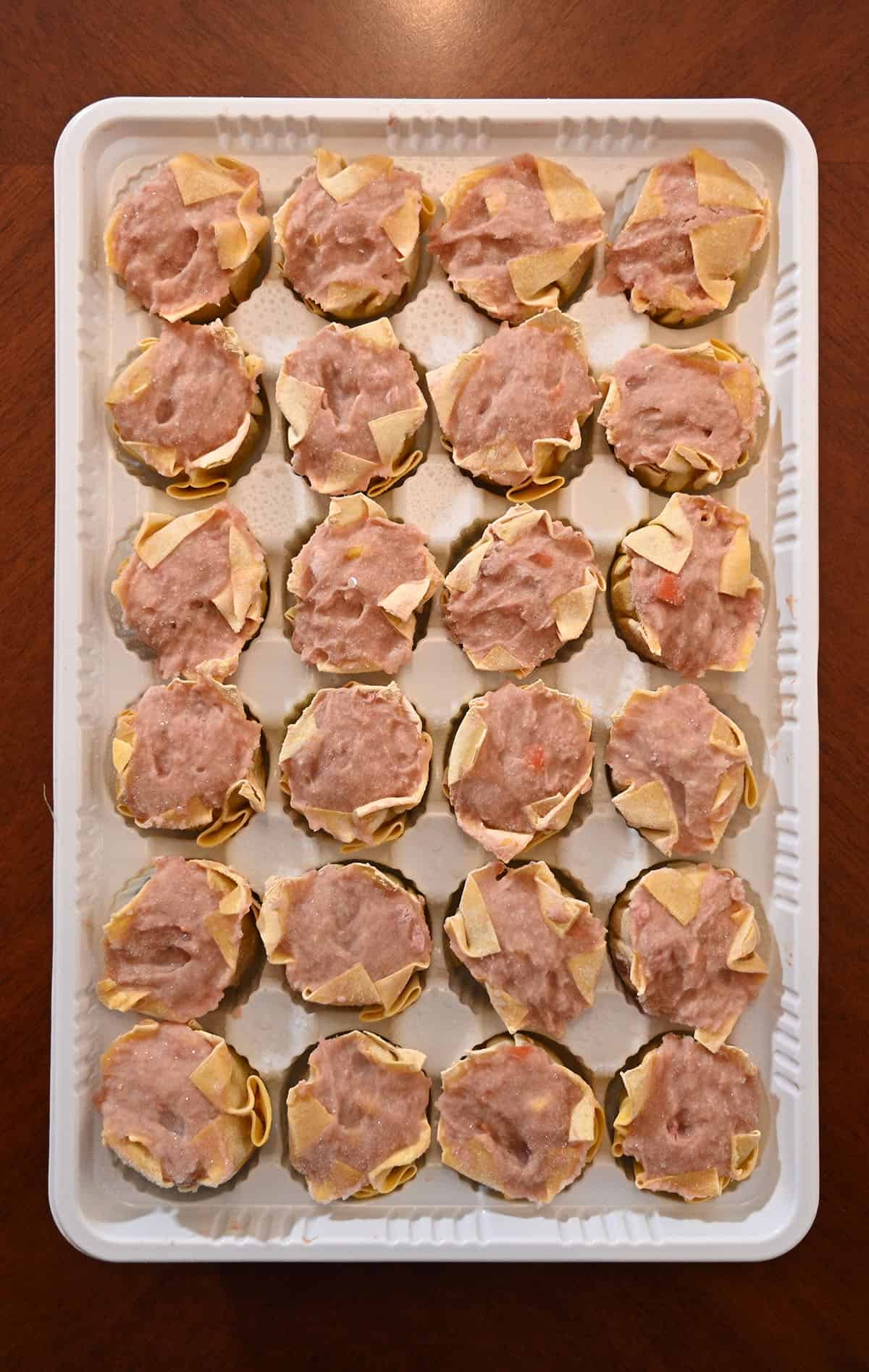 Top down closeup image of the tray of frozen dumplings that comes in the package.