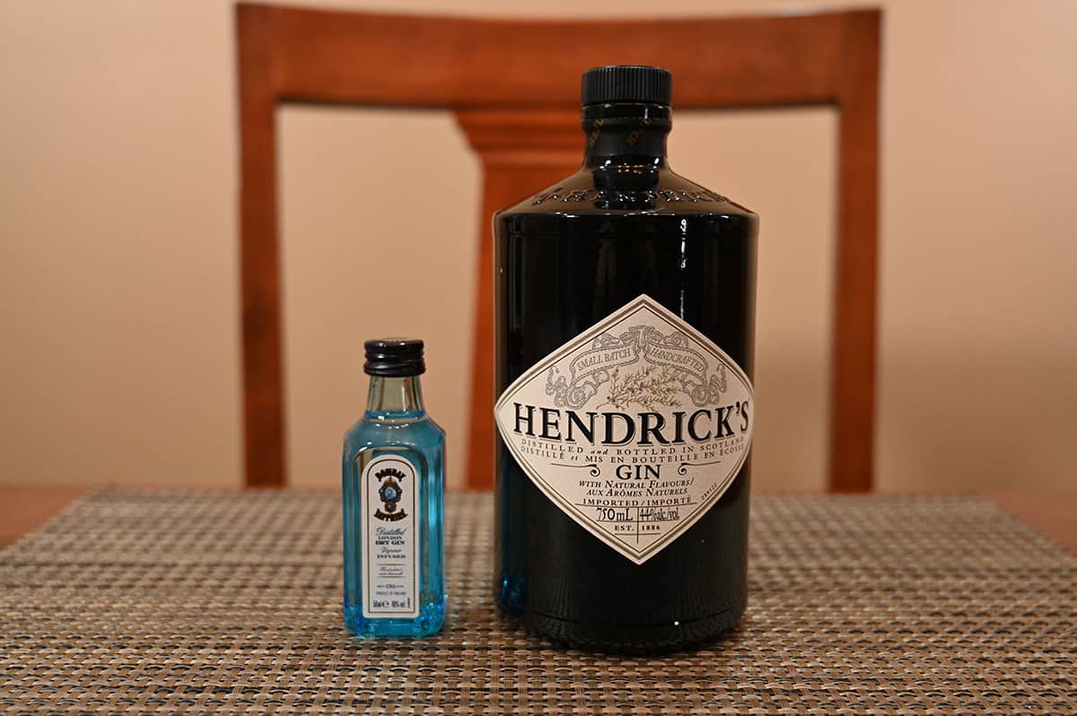 Image of a bottle of Hendrick's gin beside a bottle of Bombay Sapphire gin on a table.