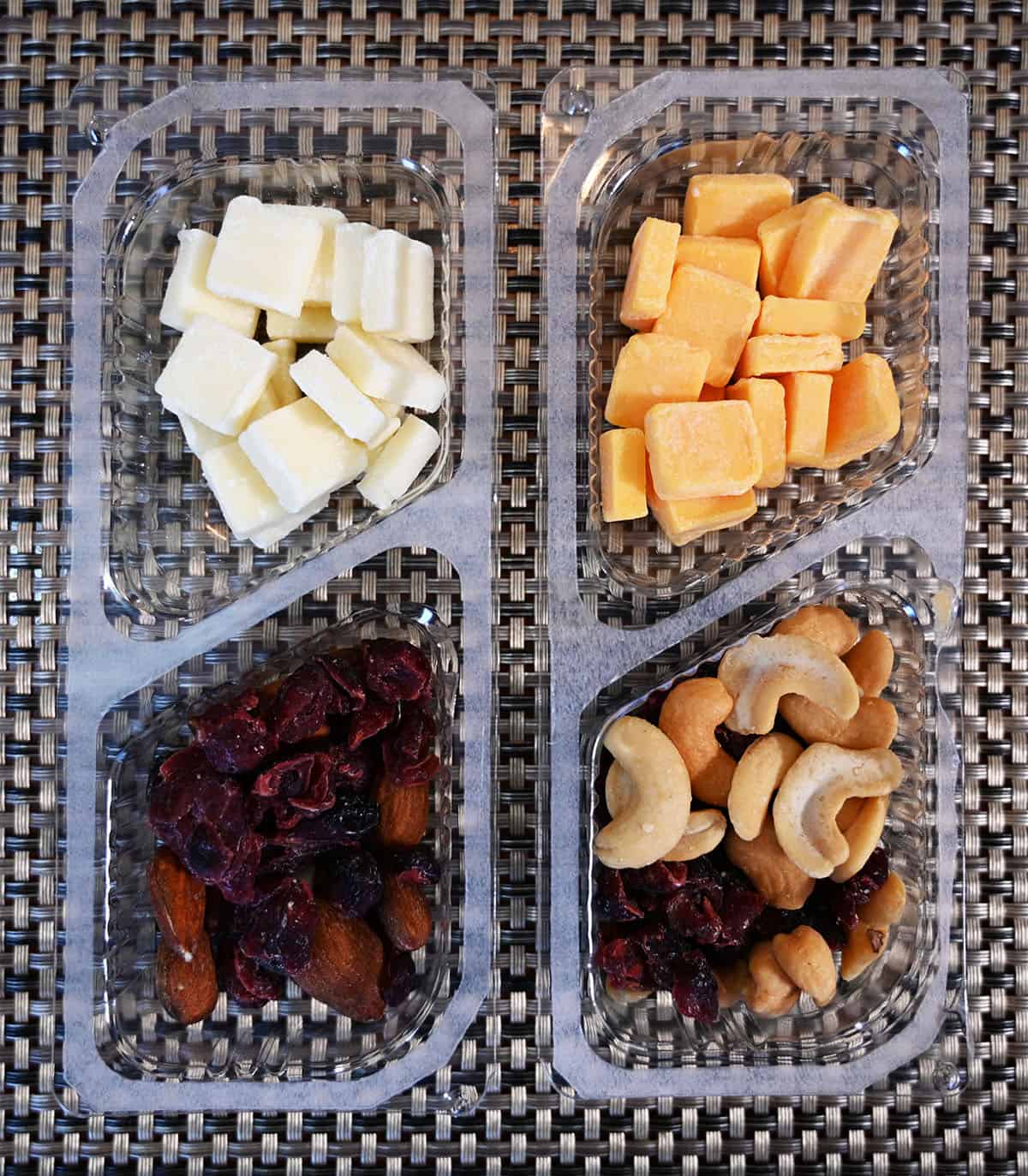 Top down image of the two kinds of cheese, fruit and nut packs open so you can see the contents in the two packs.
