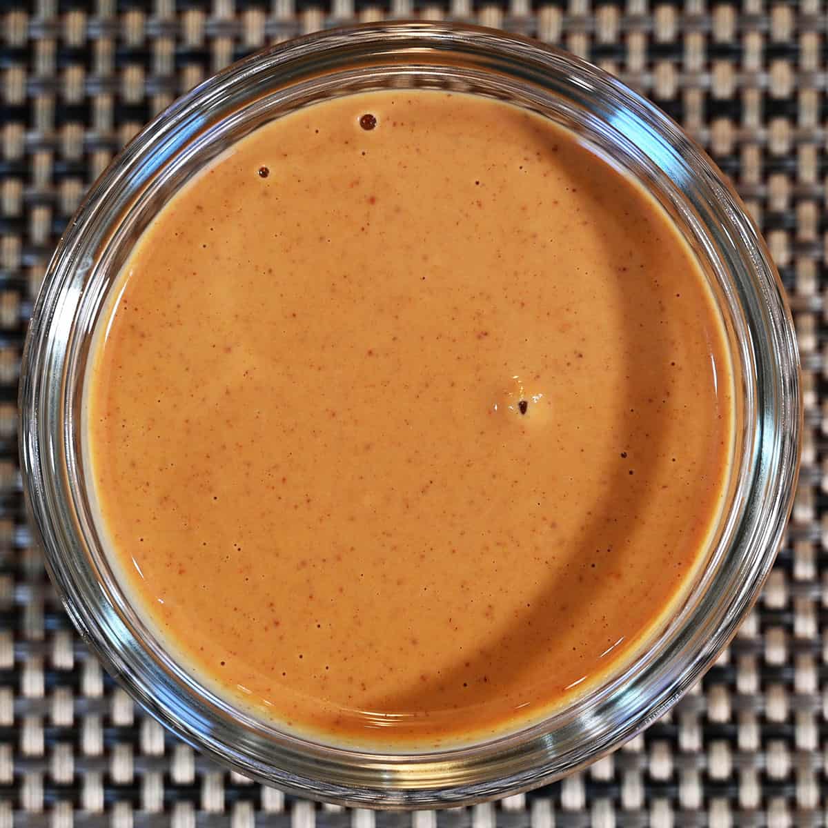 Closeup top down image of a bowl of prepared peanut butter sitting on a table.