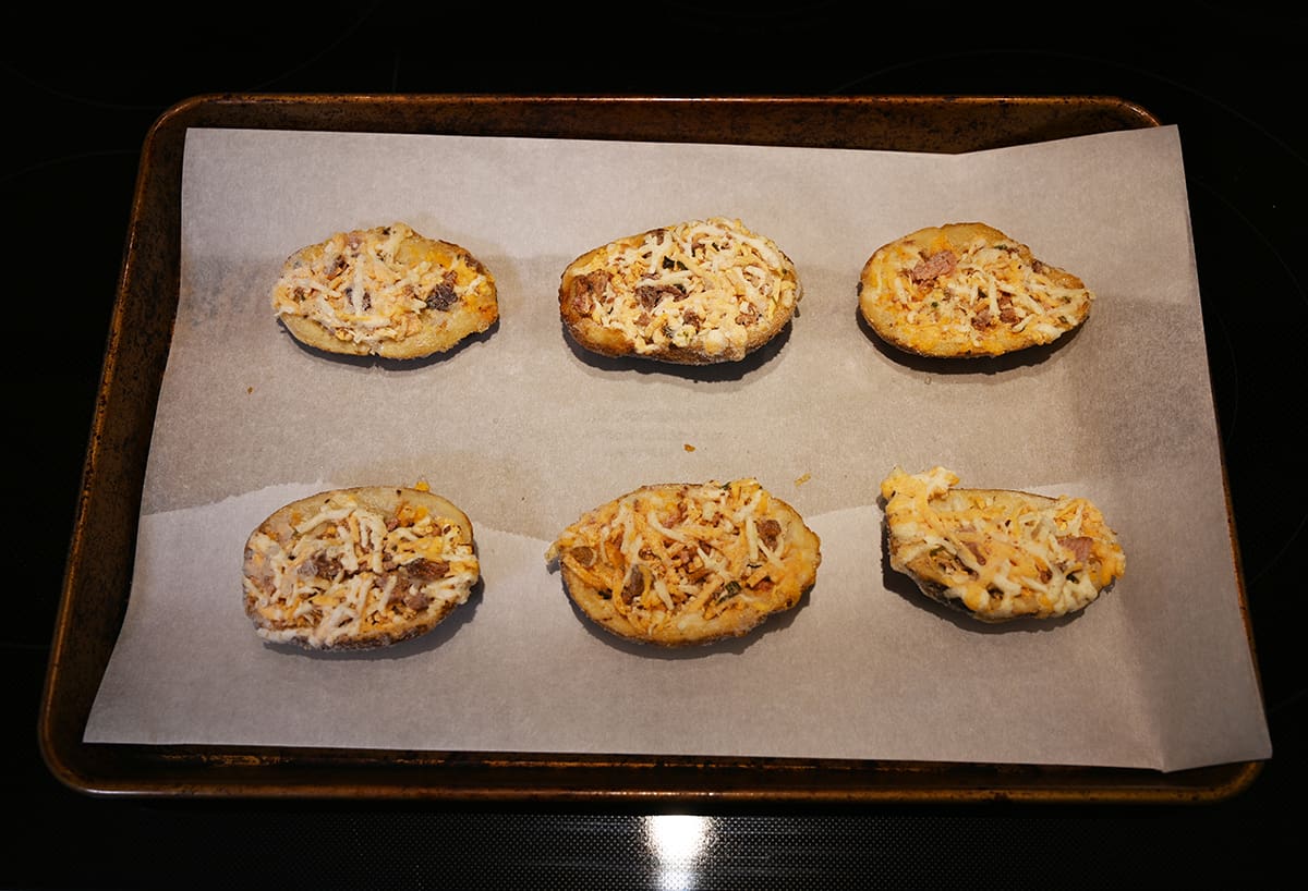 Image of six frozen potato skins on a baking tray prior to being baked.