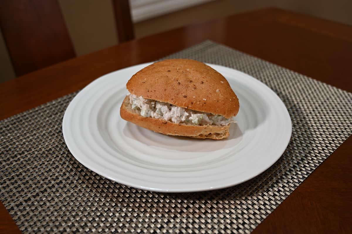 Image of one 9 Grain Costco Ciabatta Bun on a white plate filled with chicken salad.