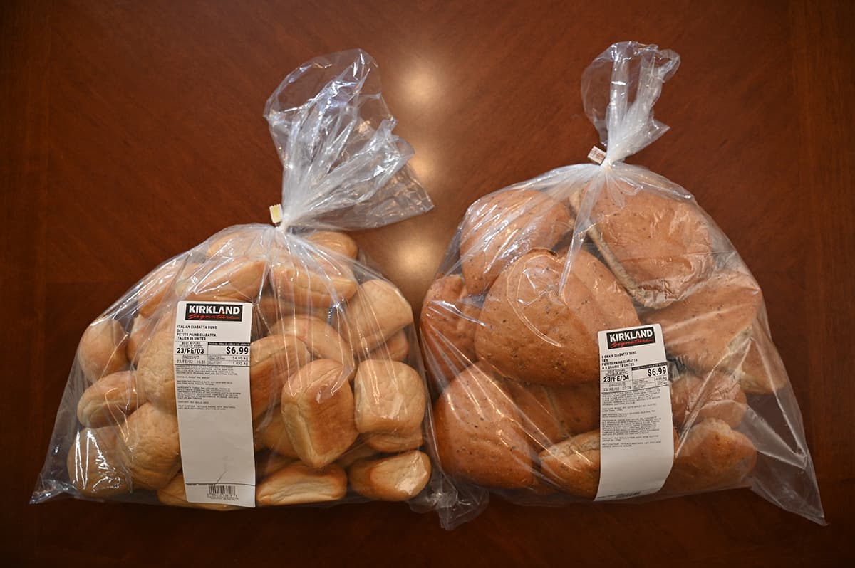 Image of two bags of the Costco Kirkland Signature Ciabatta Buns sitting on a table, one bag has Italian ciabattas and one has 9 Grain.