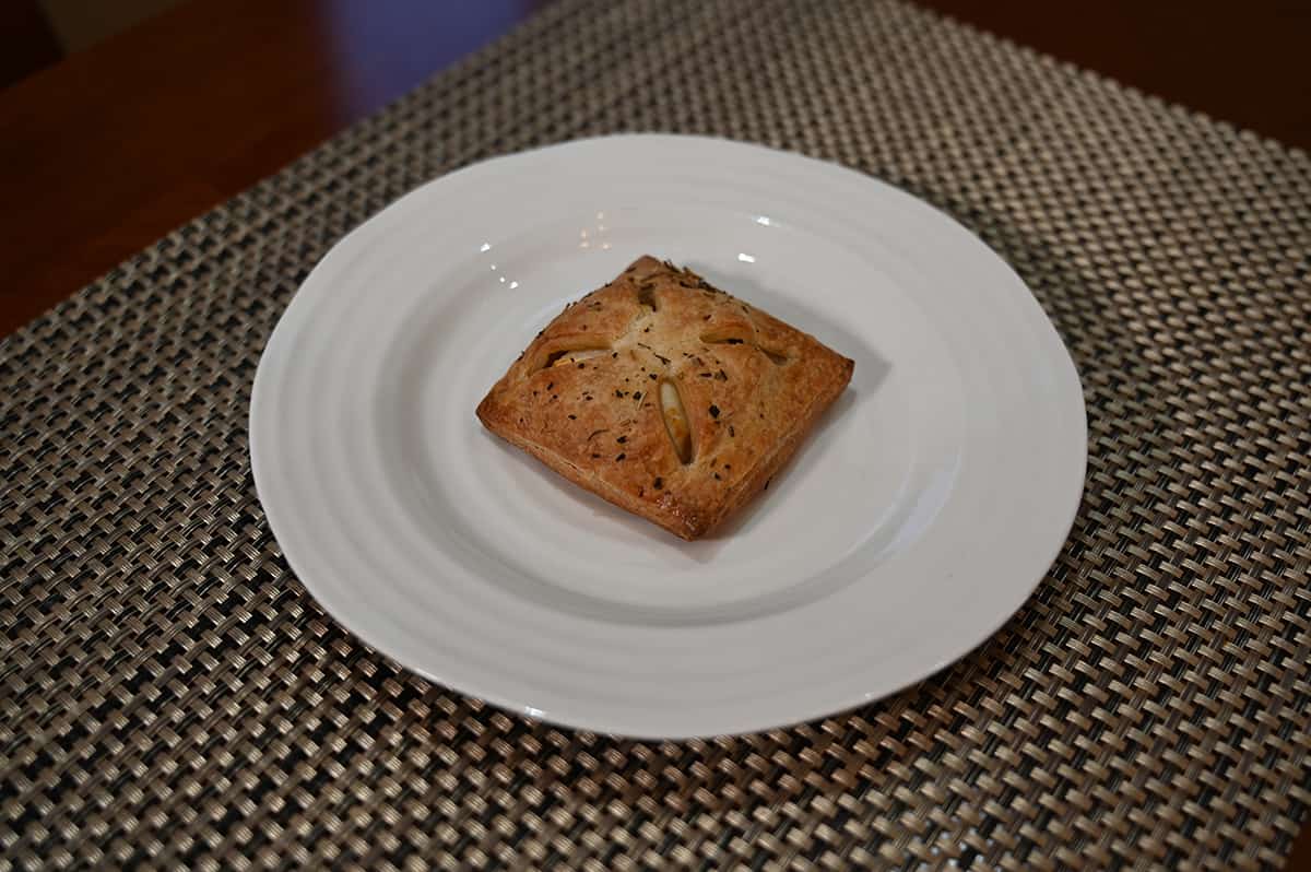 Sideview top down image of one pastry baked and served on a white plate.