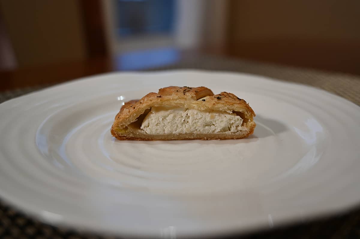 Side view image of one pastry cut in half so you can see the goat cheese on the inside.