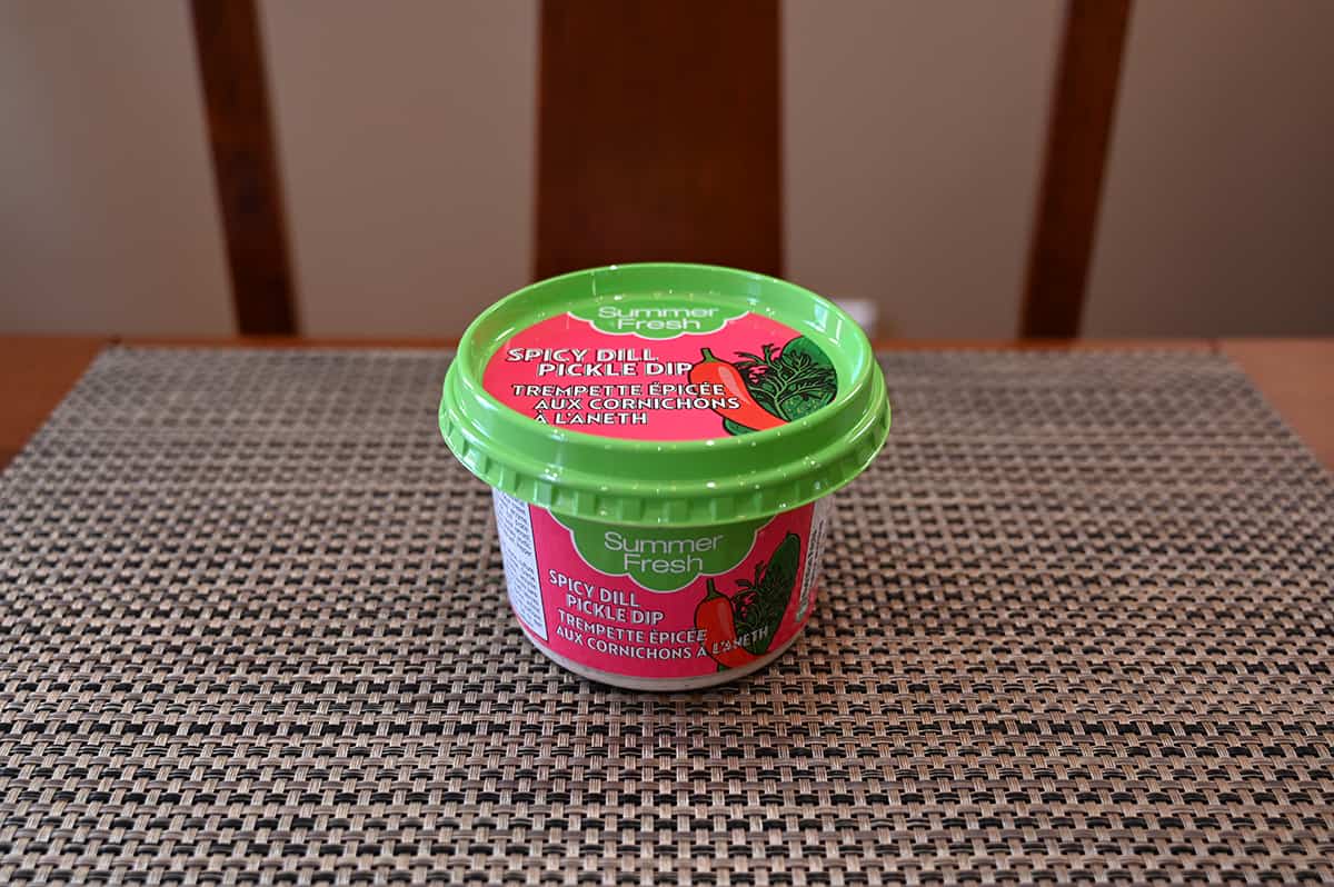 Image of one container of dip from the two pack sitting on a table unopened.