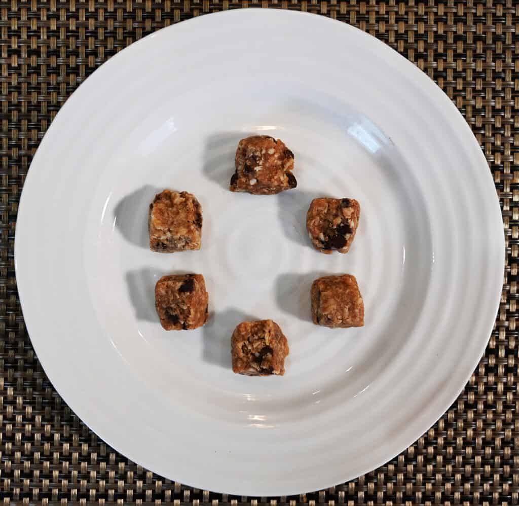 Top down image of six oatmeal chocolate flavor hunks on a white plate in a circular pattern.