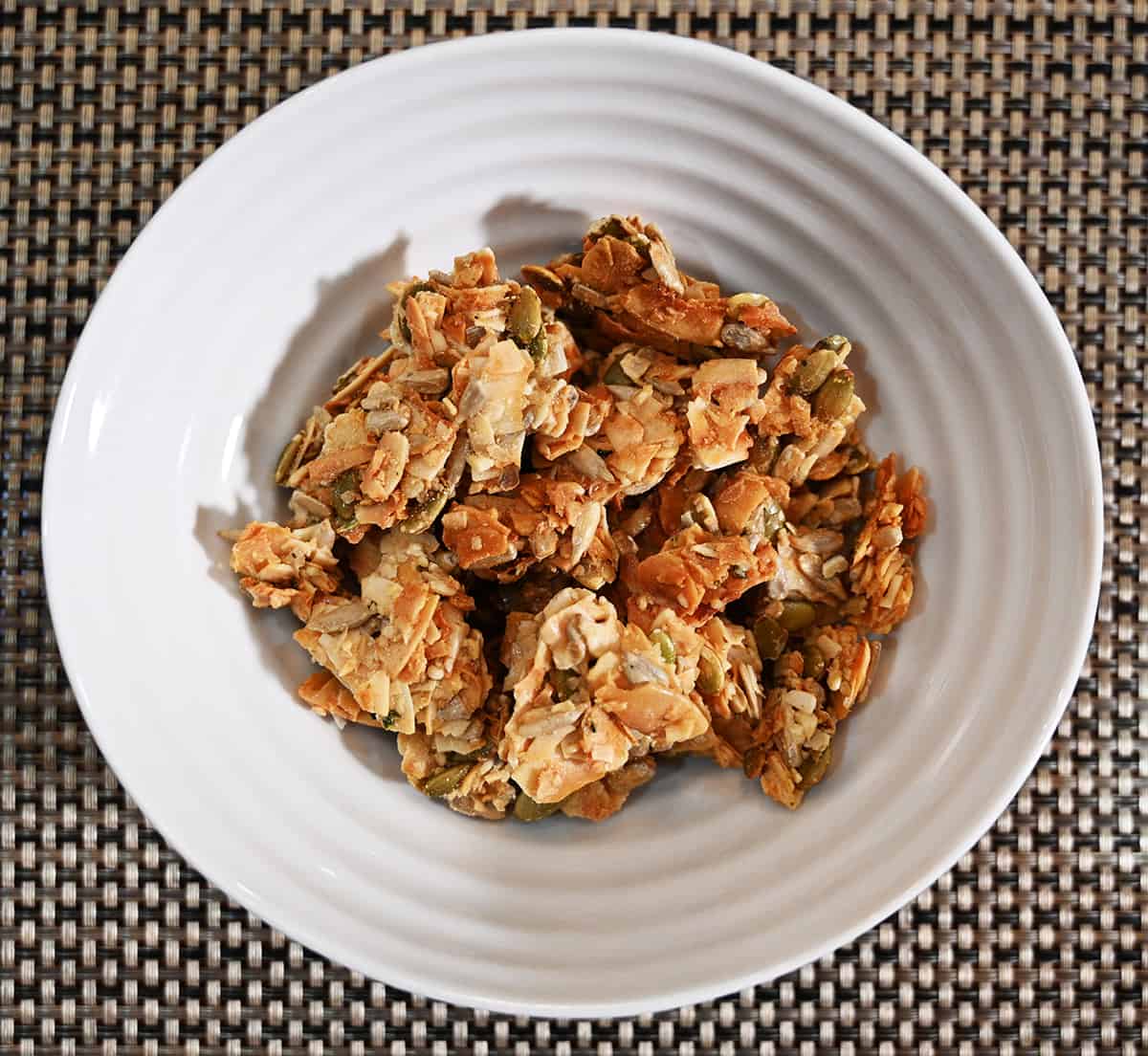 Top down image of a white bowl filled with coconut clusters.