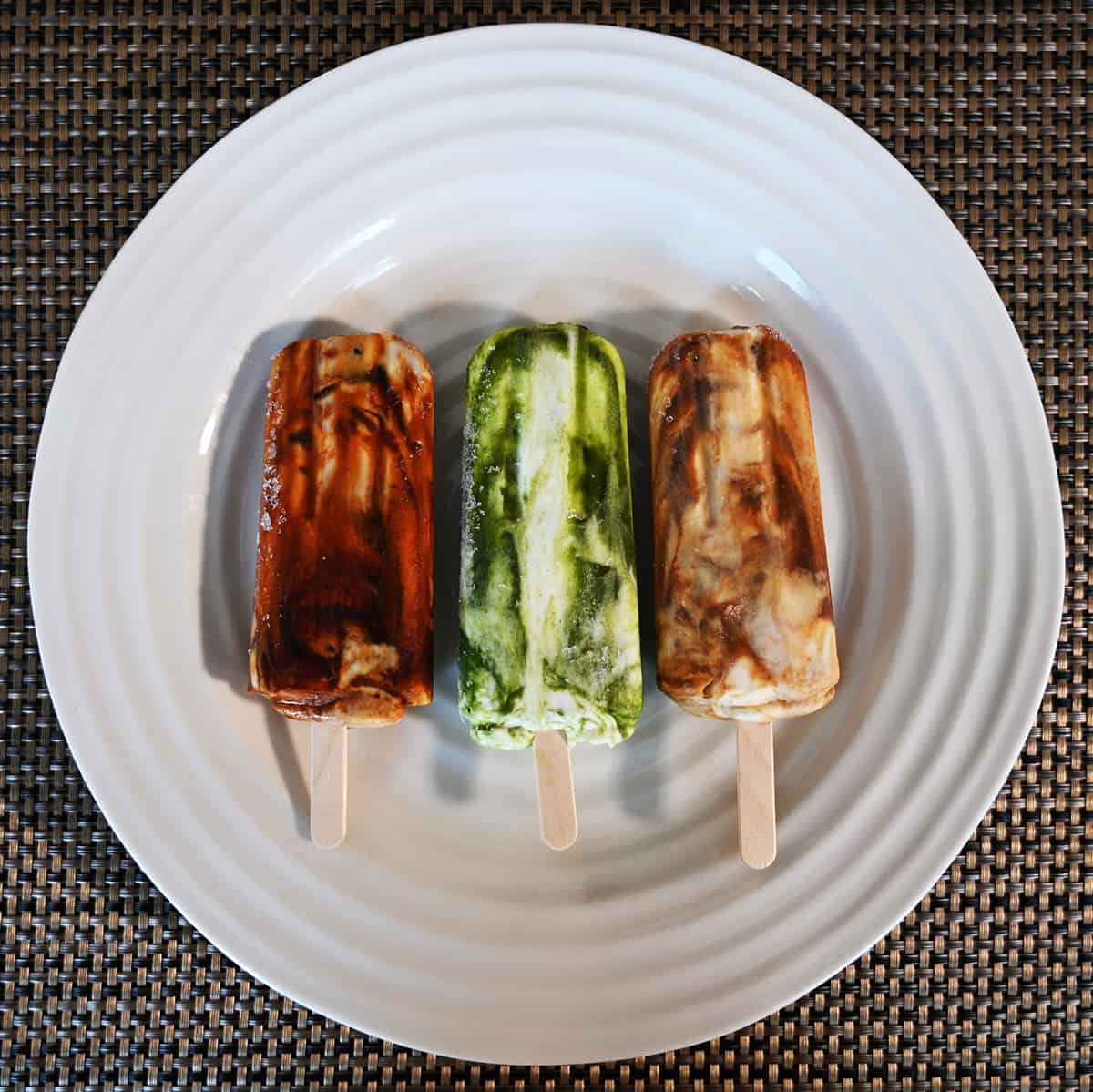 Top down image of all three flavors of bars unwrapped and resting on a white plate.