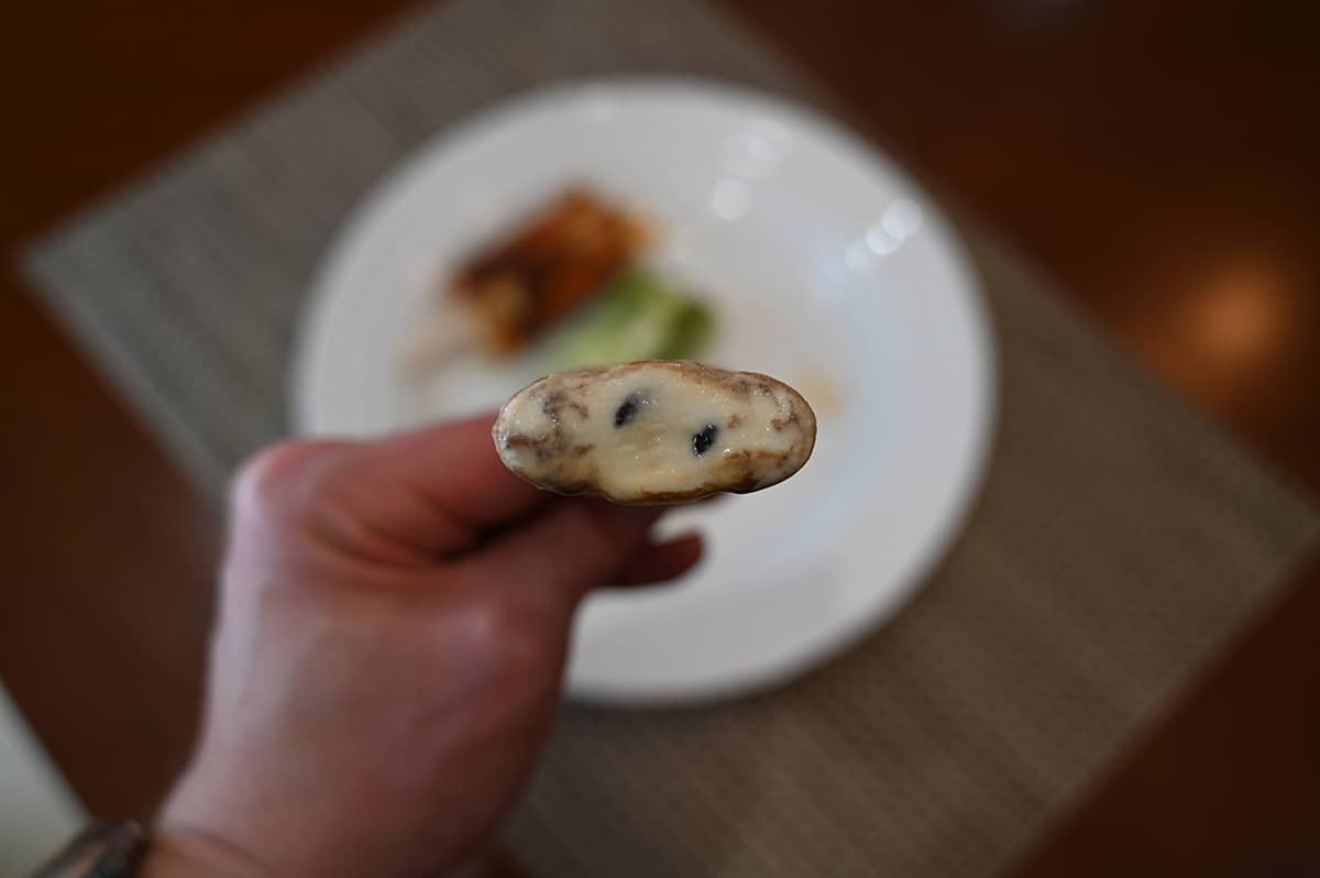 Image of a black tea latte with a bite taken out so you can see the tapioca balls inside.