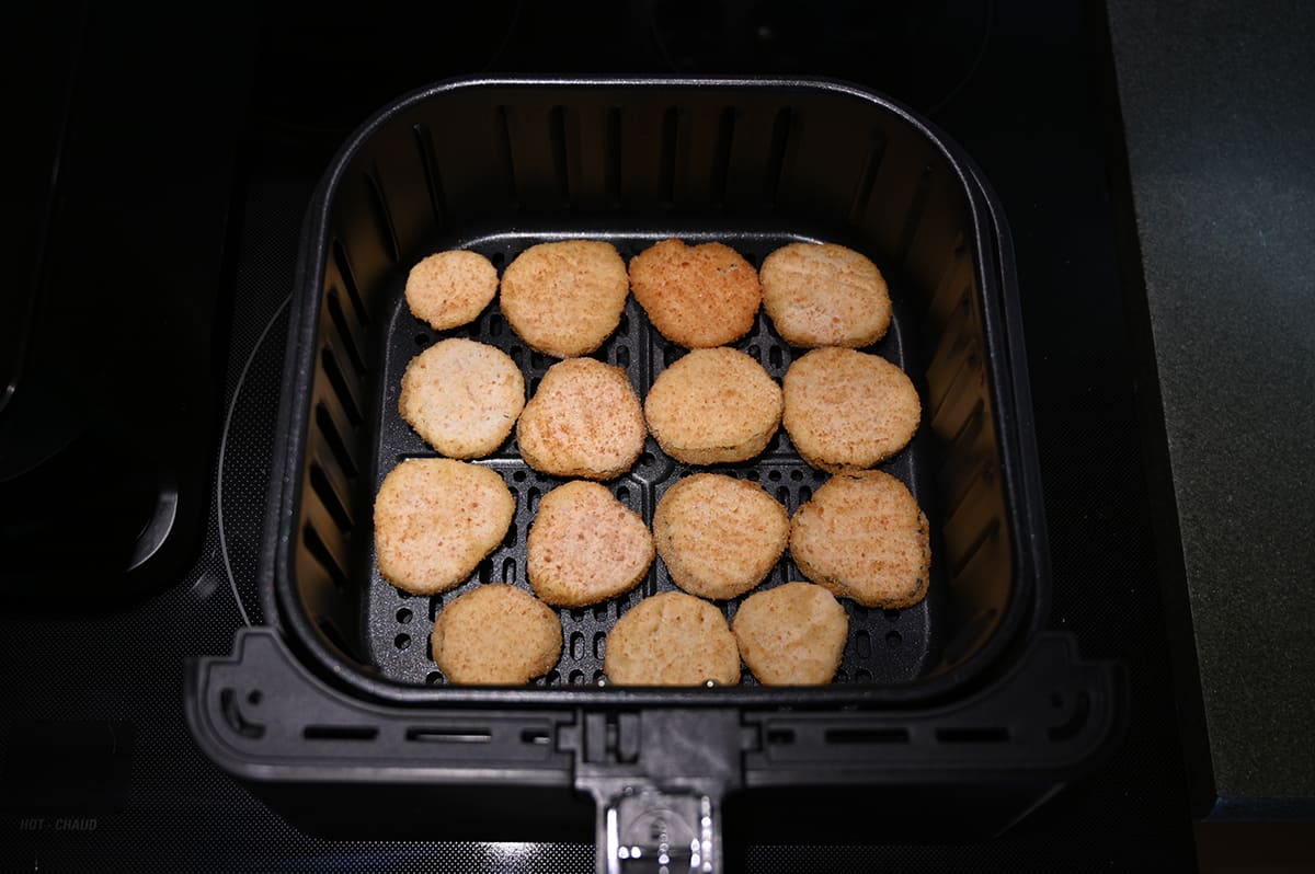 Image of an air fryer tray full of dill pickle chips prior to cooking them.