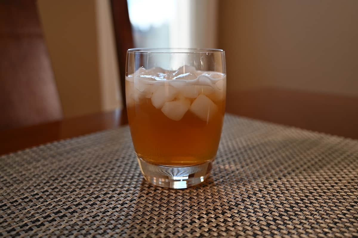 Image of a glass of prepared iced tea with ice in it, sitting on a table.