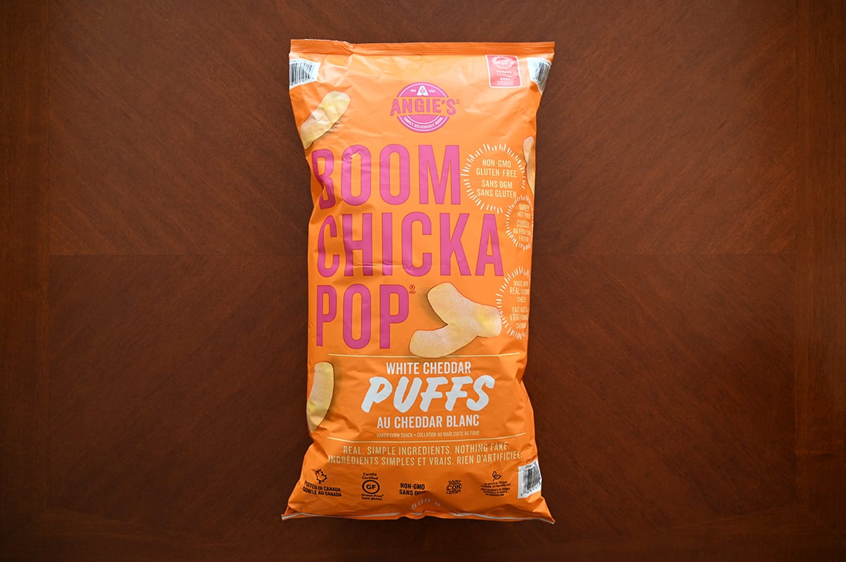 Image of the Costco Angie's Boom Chicka Pop White Cheddar Puffs bag sitting on a table.