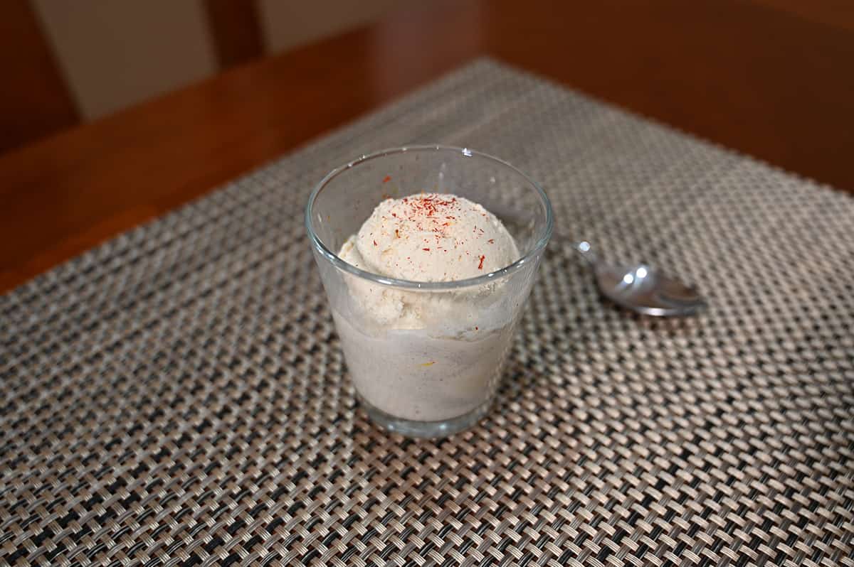 Image of a small cup of vanilla ice cream with saffron sprinkled on top.