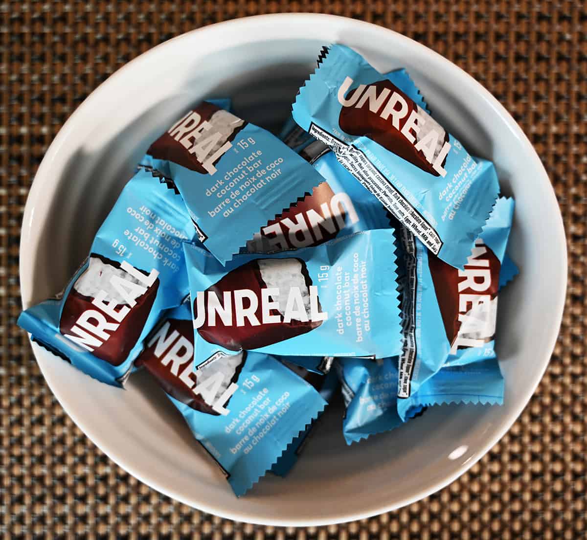 Top down image of the mini bars in a their individual wrappers served in a white bowl.