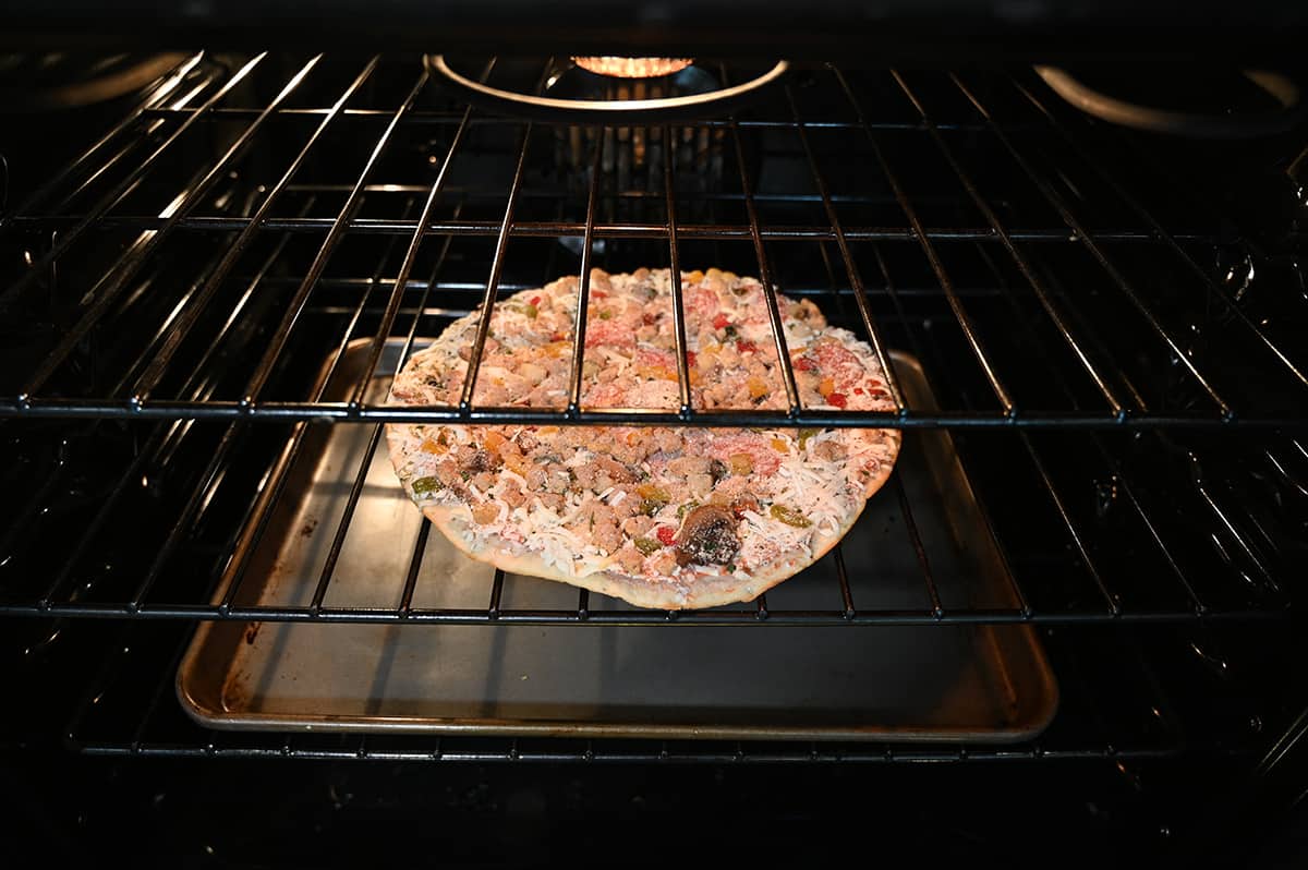 Image of a frozen pizza being cooked in the oven placed directly on the oven rack.