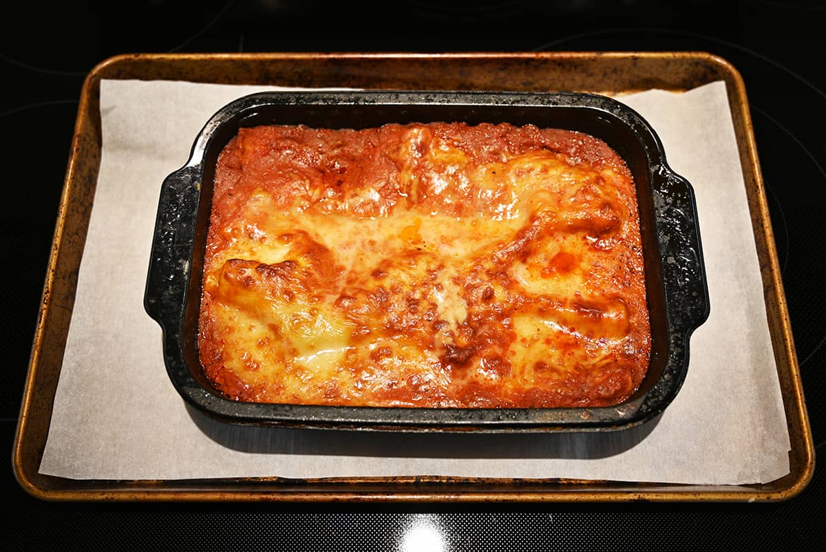 Top down image of the whole cooked lasagna in the tray on a baking sheet after coming out of the oven.