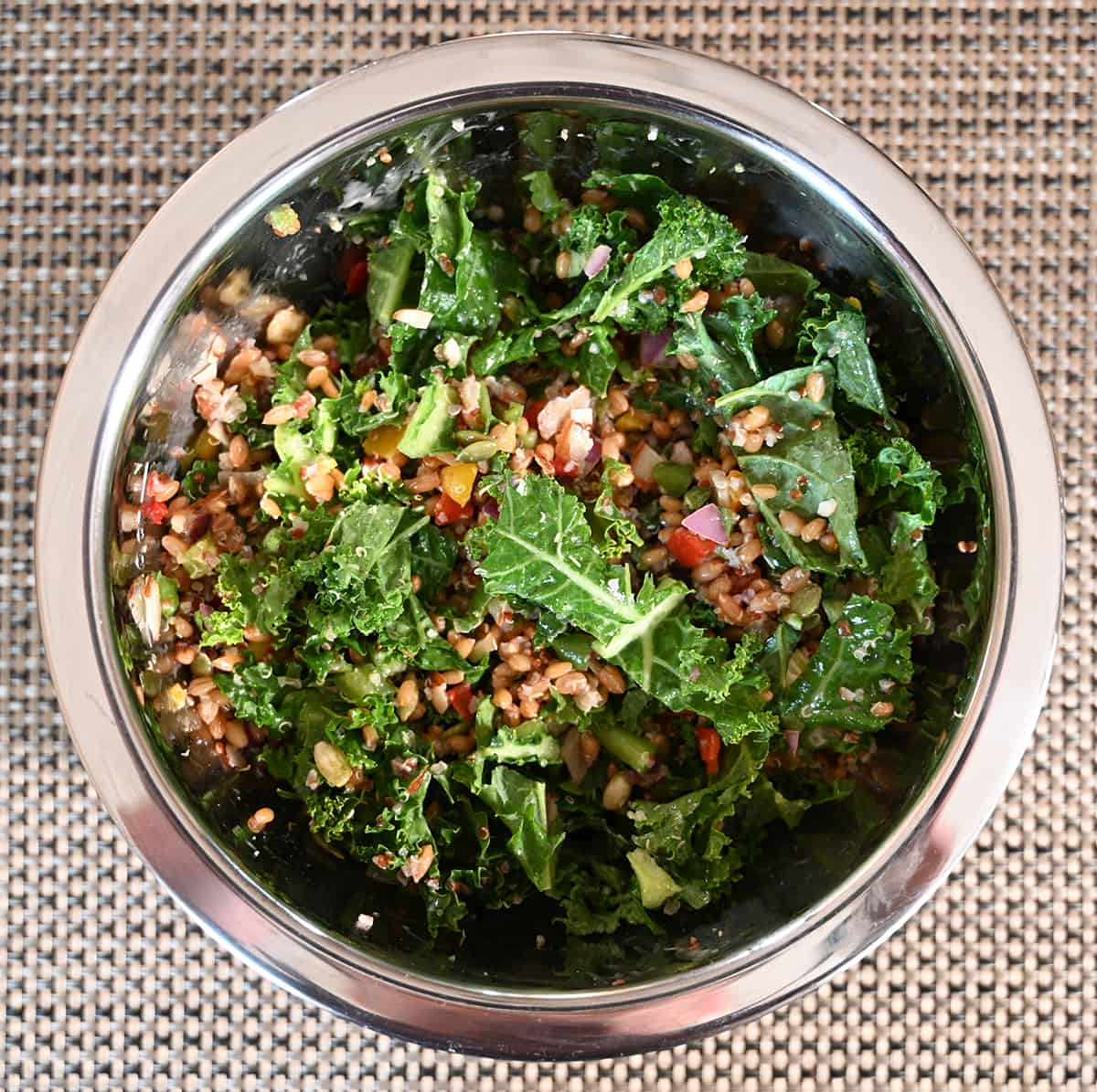 Top down image of the salad served in a big stainless steel bowl, sitting on a table.