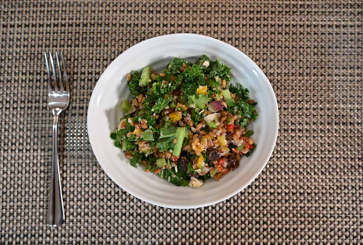 Top down image of the salad served in a white bowl with a fork resting beside it.