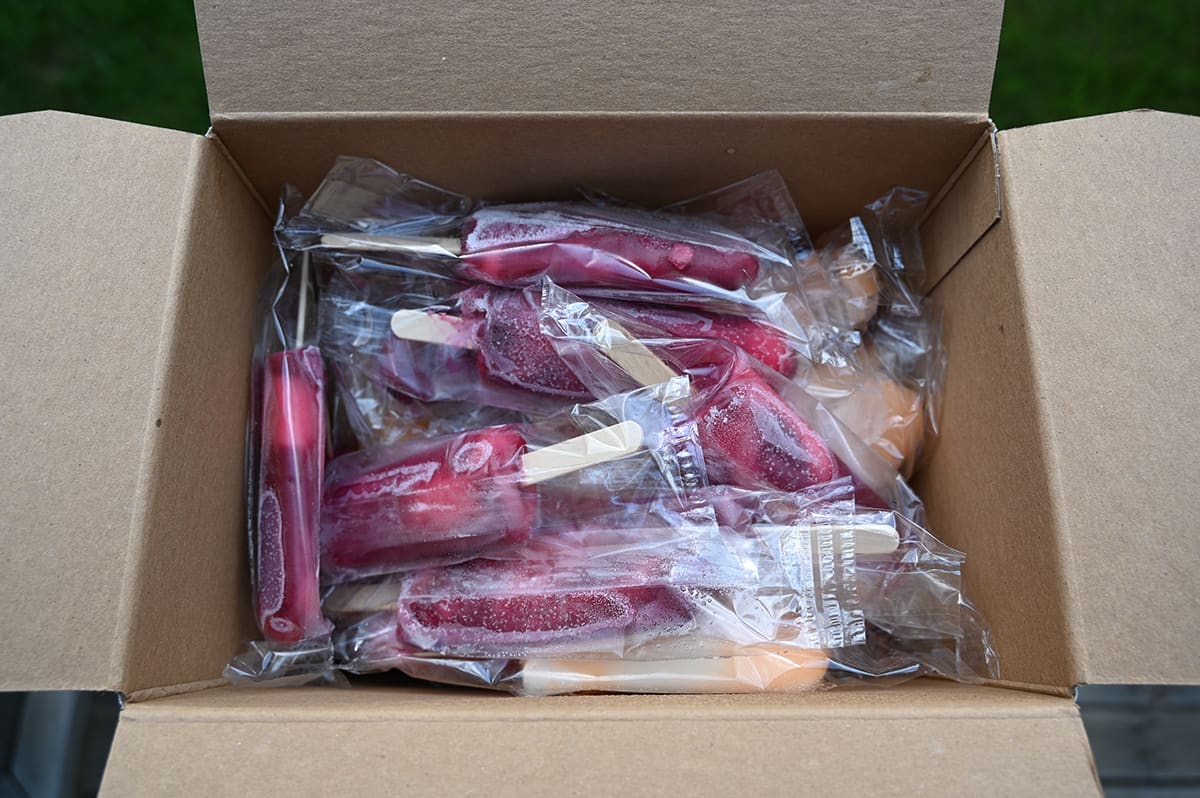 Top down image of an open box of PhillySwirl Stix showing the individually wrapped popsicles loose in the box.