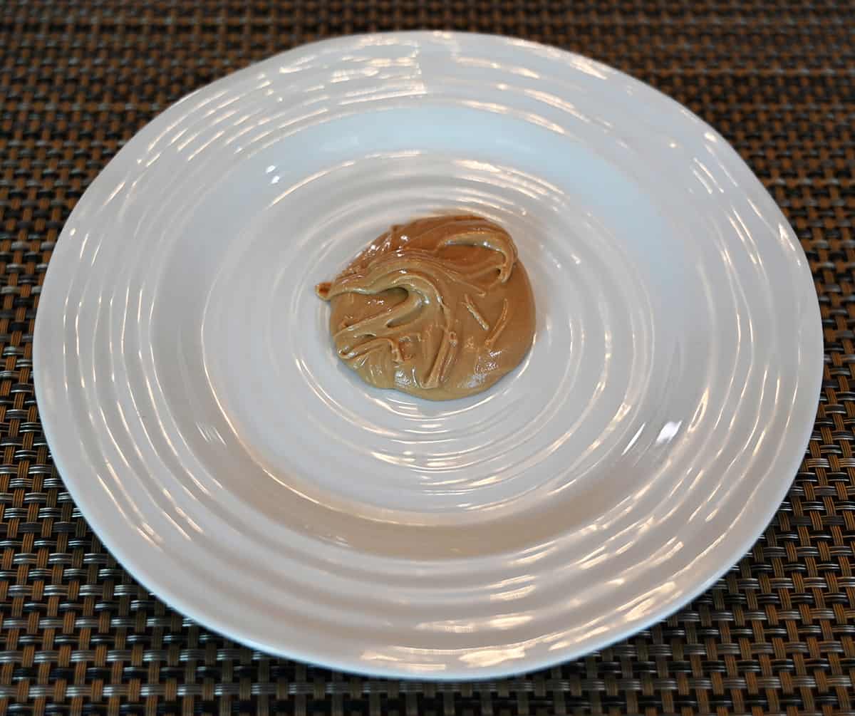 Image of a tablespoon of almond cream on the middle of a white plate.