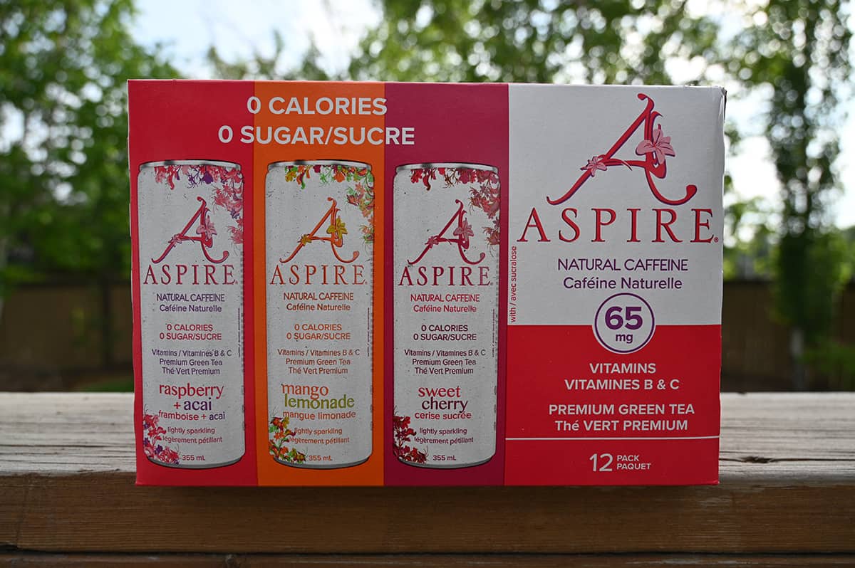 Image of the Costco Aspire Energy Drink with Natural Caffeine case sitting on a table outside with trees in the background.