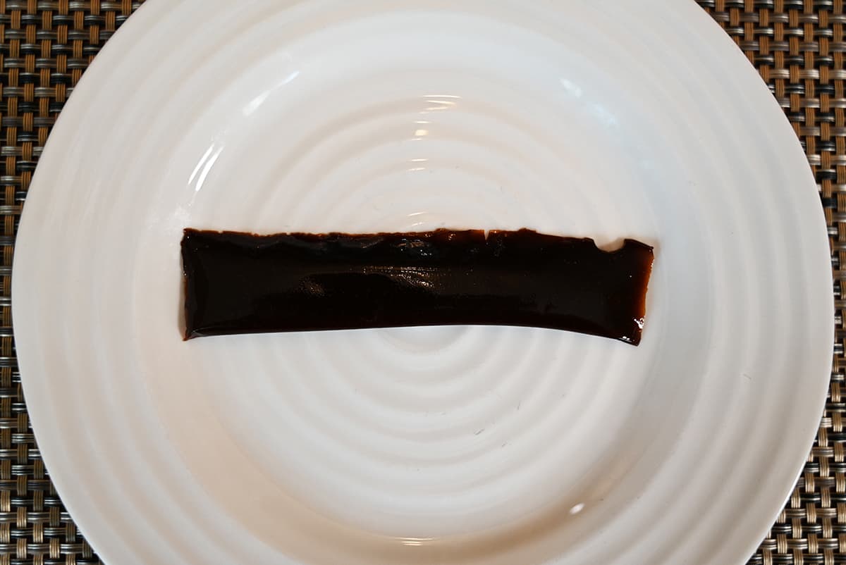 Top down image of one jelly stick laying on a white plate.