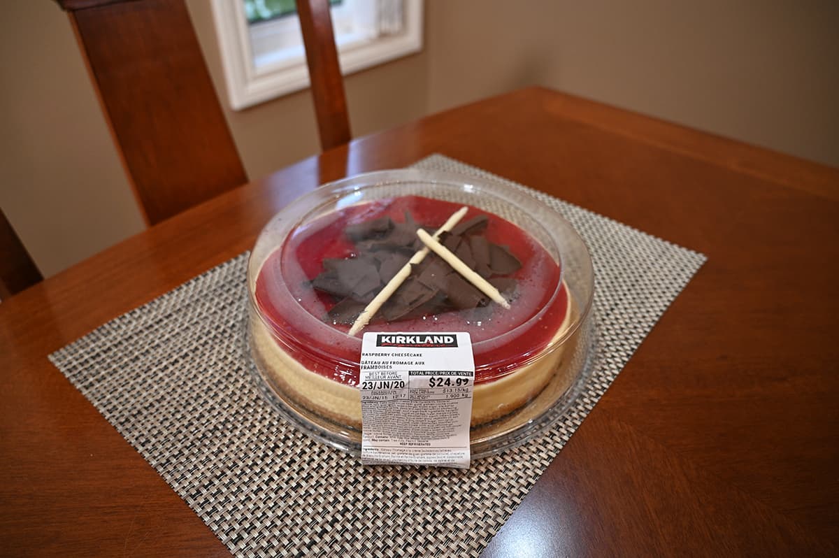 Image of the Costco Kirkland Signatuee Raspberry Cheesecake sitting on a table in the packaging.