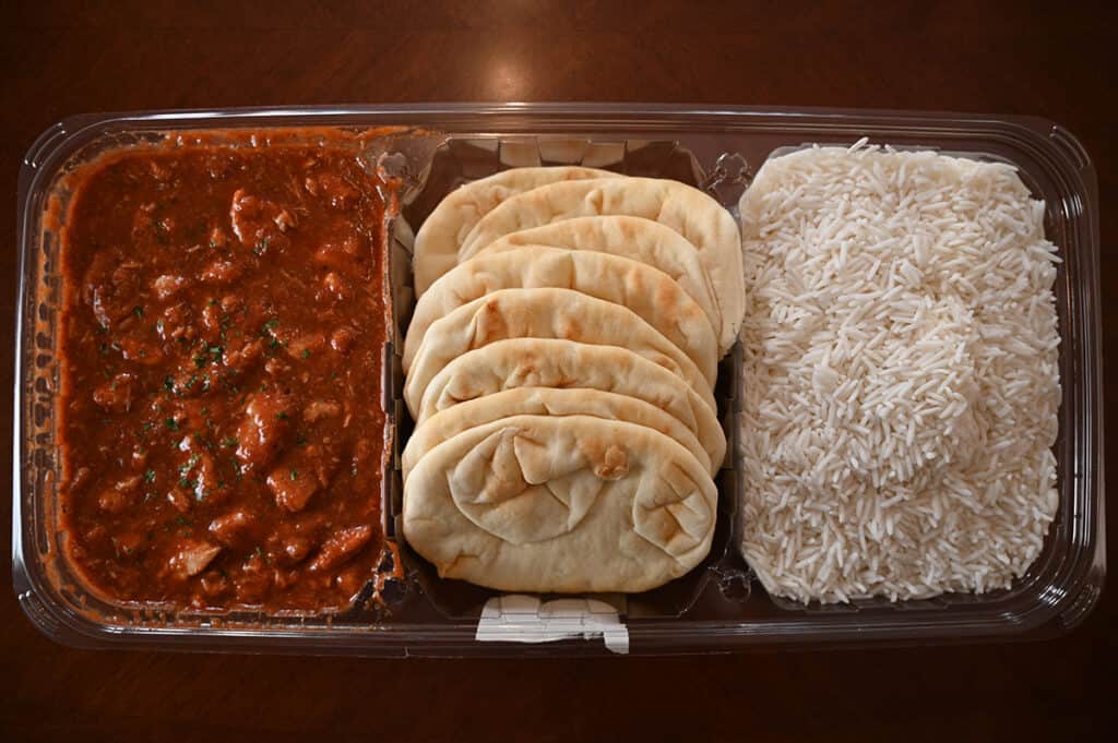 Top down image of the Kirkland Signature Chicken Vindaloo package with the lid off showing the vindaloo, naan and rice.