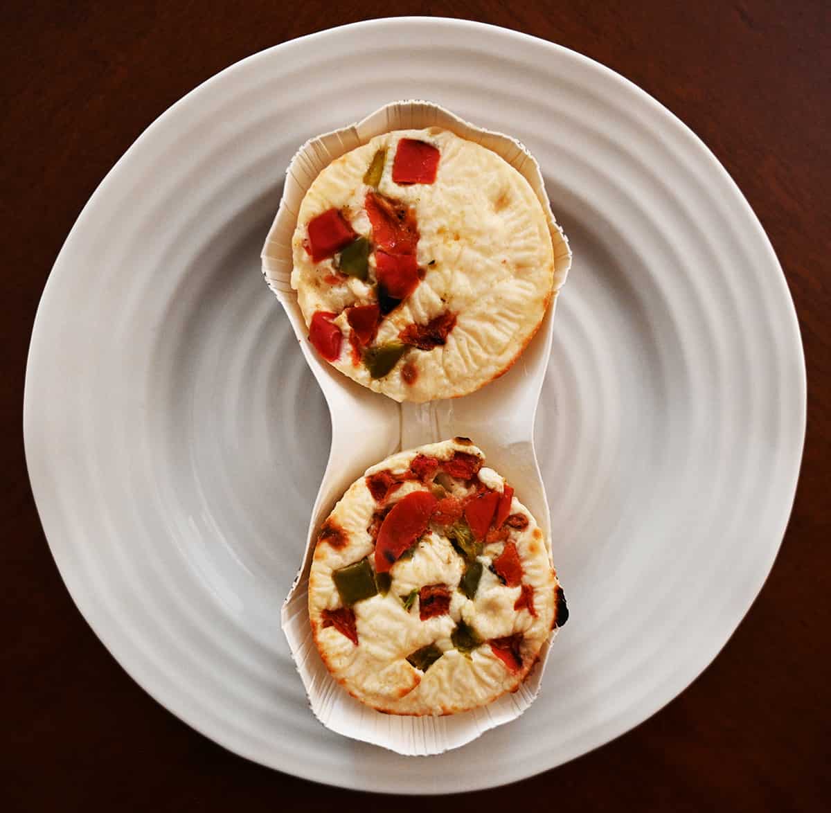 Top down image of the spinach & bell pepper egg bites in their package out of the wrapper, prior to cooking.