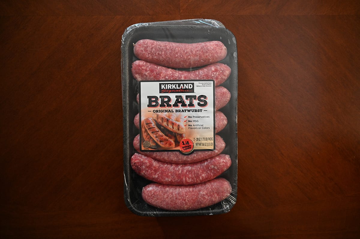 Image of the Costco Kirkland Signature Brats tray unopened with uncooked brats sitting on a table.