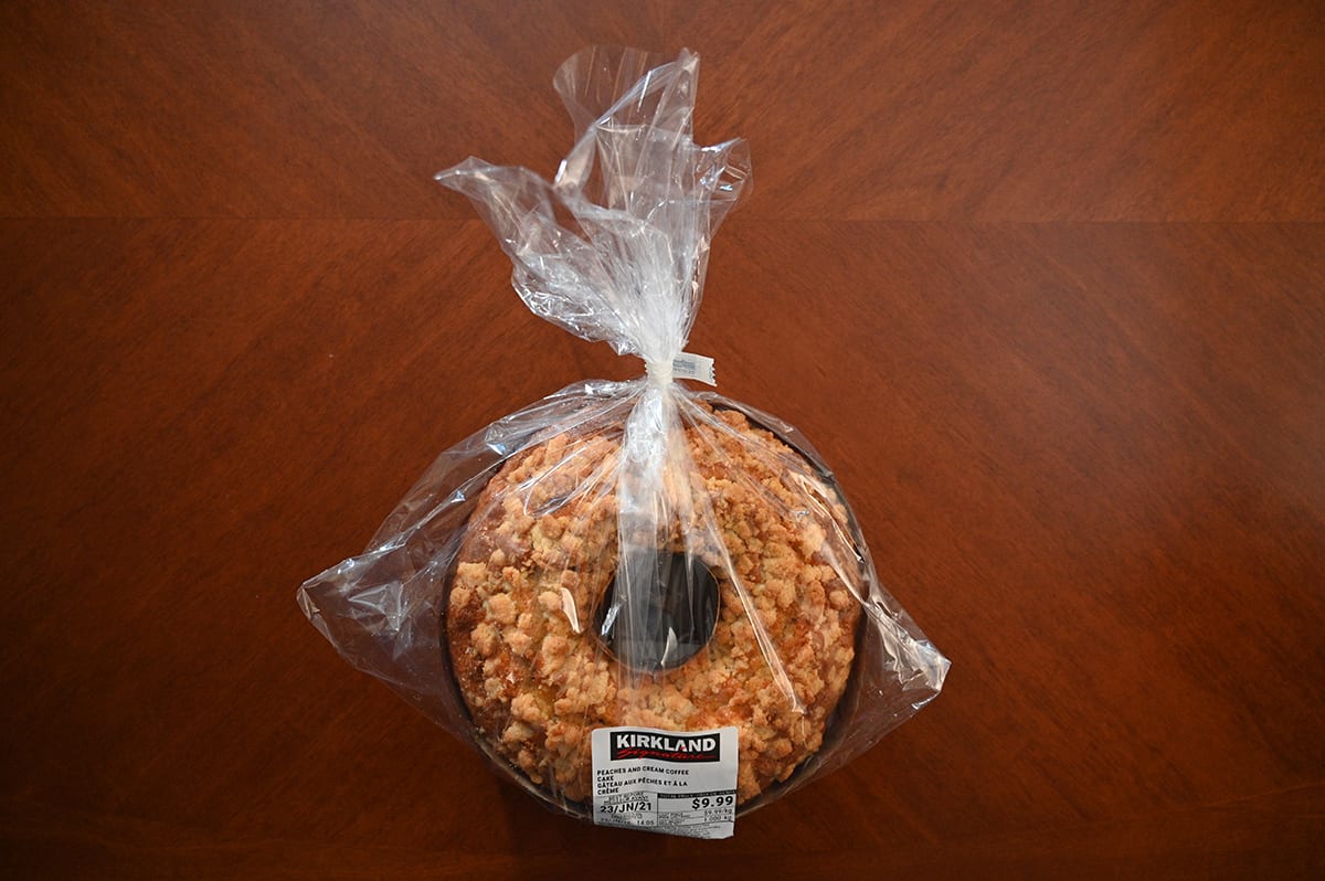 Top down image of the Costco Kirkland Signature Peaches and Cream Coffee Cake in plastic packaging sitting on a table.