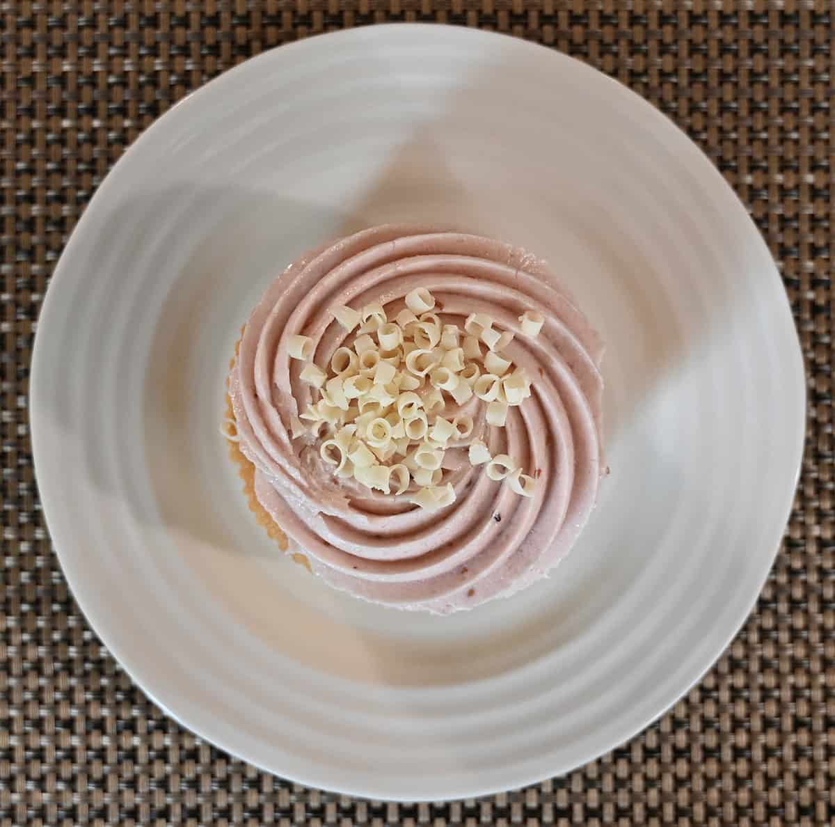 Top down image of one mini raspberry cake served on a white plate.