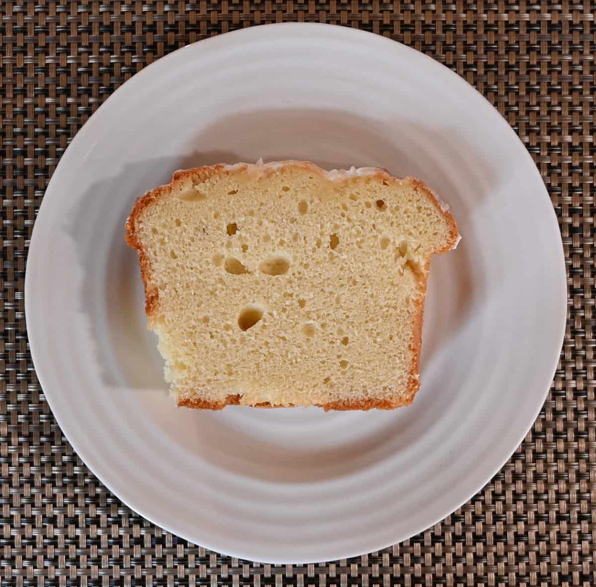 Top down image of a slice of pound cake served on a white plate.