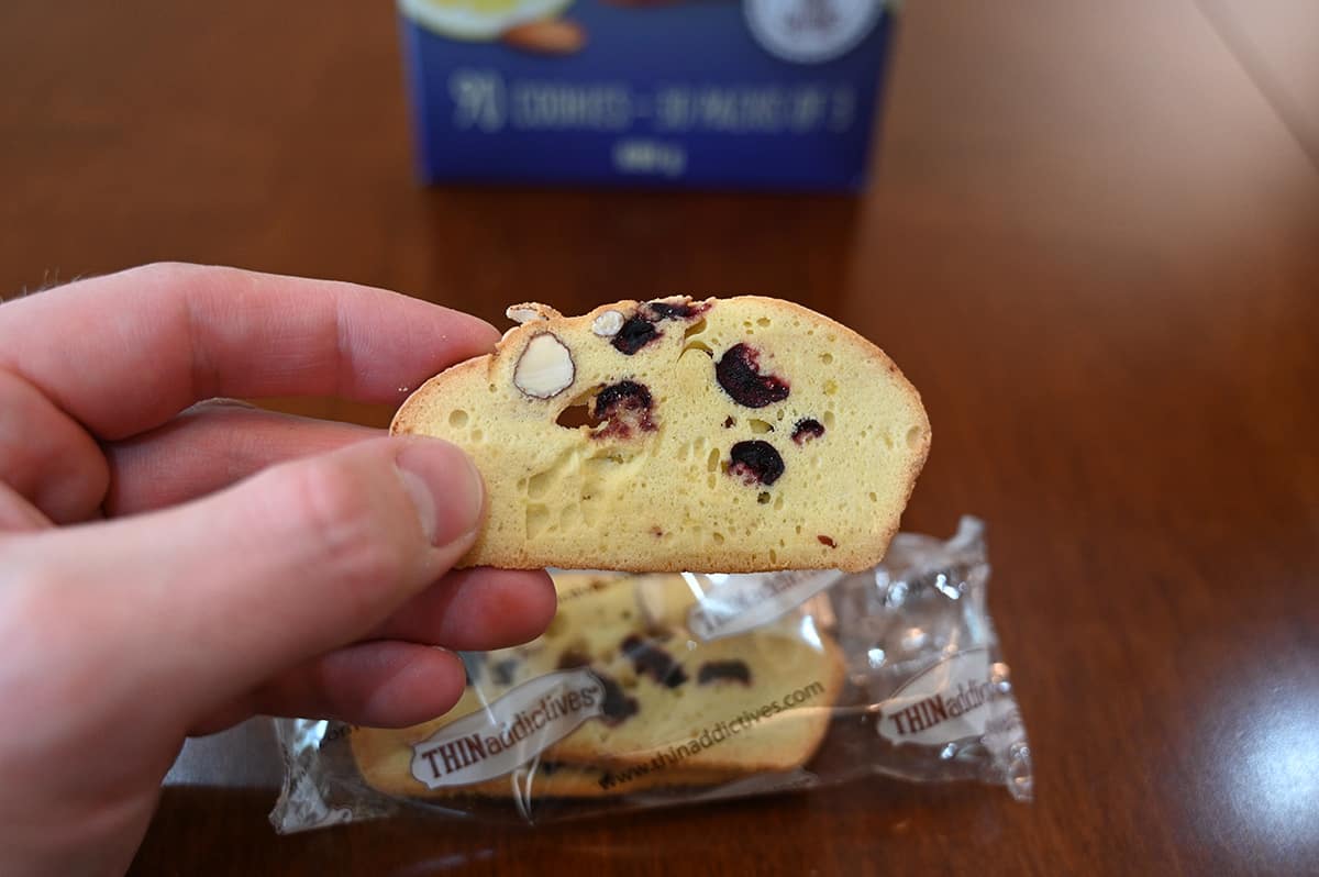 Closeup image of a hand holding one Thinaddictive from the packet close to the camera.