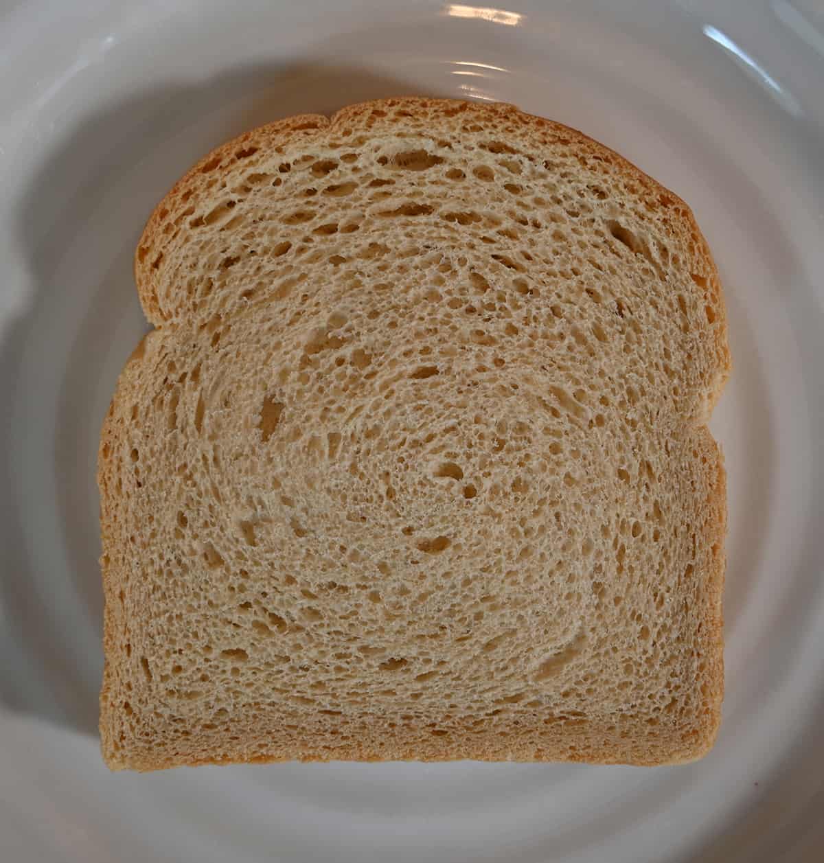 Top down image of one slice of bread served on a white plate.