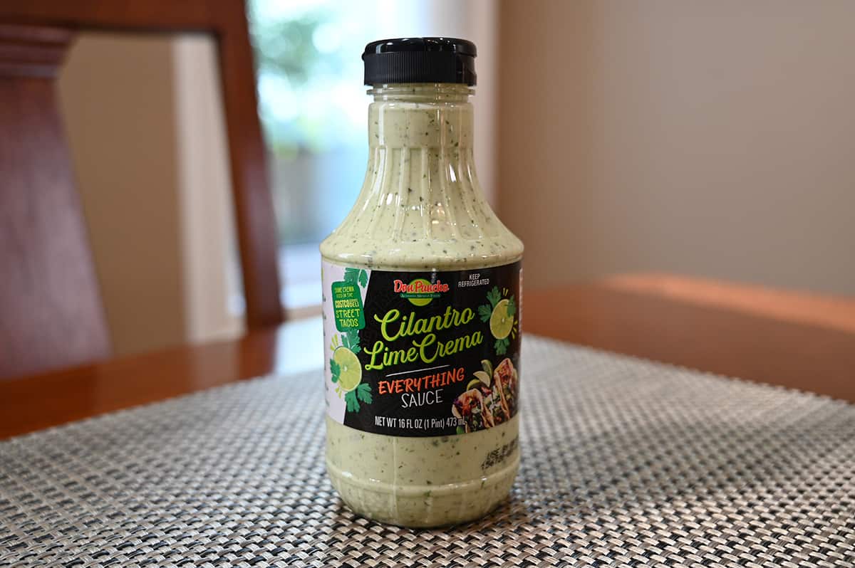 Image of one unopened bottle of crema sitting on a table.