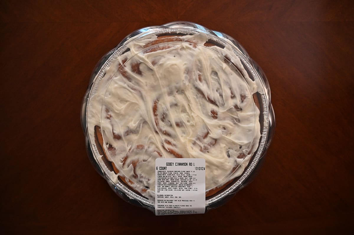 Image of an unopened circular aluminum container of the Costco Kirkland Signature Gooey Cinnamon Roll sitting on a table.