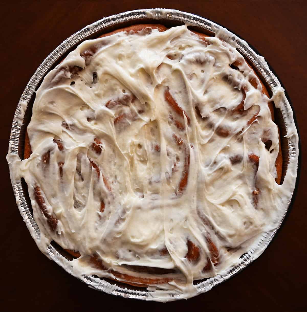 Top down closeup image of the container of cinnamon rolls with the lid off, the rolls aren't heated yet.